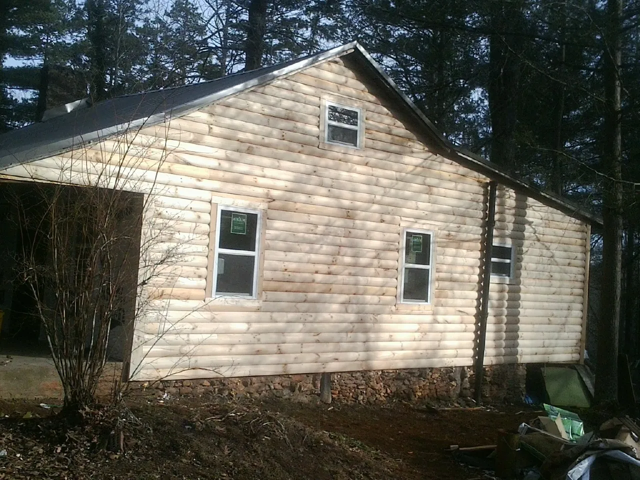 New log siding and dark metal roofing on a gable end in Leeds